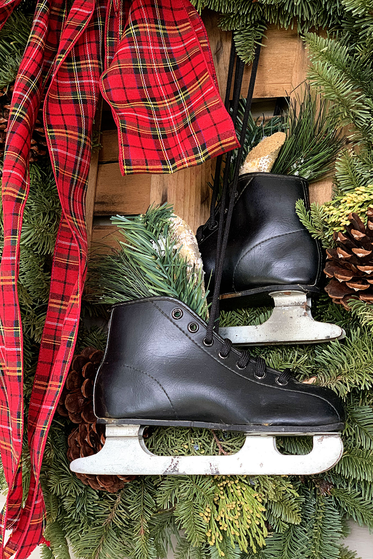 Black boys ice skates used as decoration on a Christmas wreath.