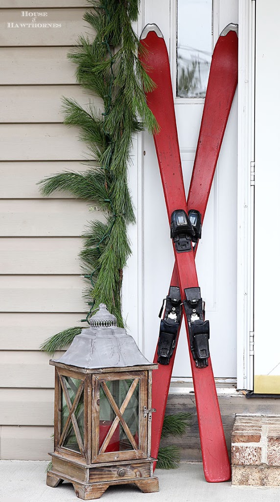 Fun holiday front porch ideas are shown, including chalk painted skis, vintage Thermoses and plaid decor for Christmas. And most of the items were found at thrift stores and estate sales.