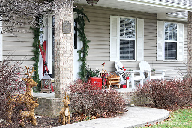 Fun holiday front porch ideas are shown, including chalk painted skis, vintage Thermoses and plaid decor for Christmas. And most of the items were found at thrift stores and estate sales.