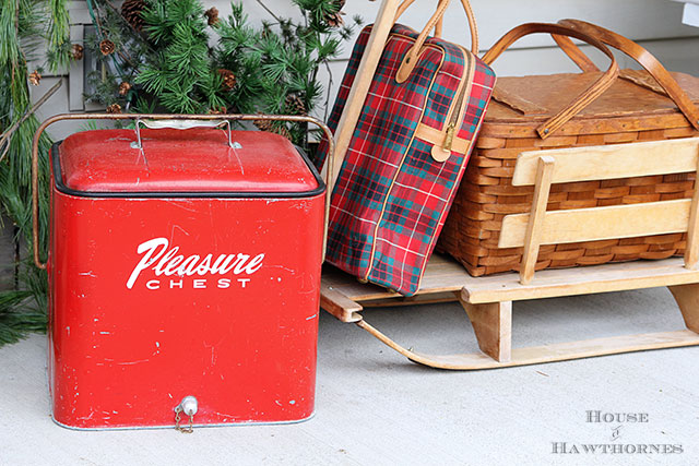 Fun holiday front porch ideas are shown, including chalk painted skis, vintage Thermoses and plaid decor for Christmas. And most of the items were found at thrift stores and estate sales.