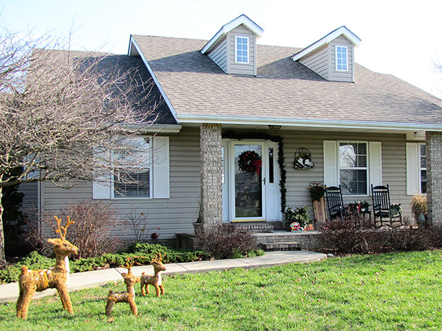 Festive DIY winter front porch with fake reindeer looking on.