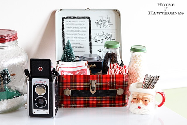 A vintage inspired hot cocoa station for the holidays. Cute ideas for a Christmas display! Love the old Santa mug, vintage camera and plaid school lunchbox!