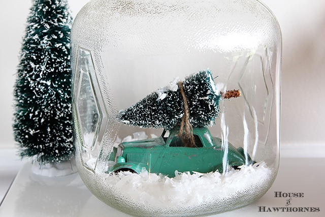 Car with Christmas tree tied to top in a snow jar