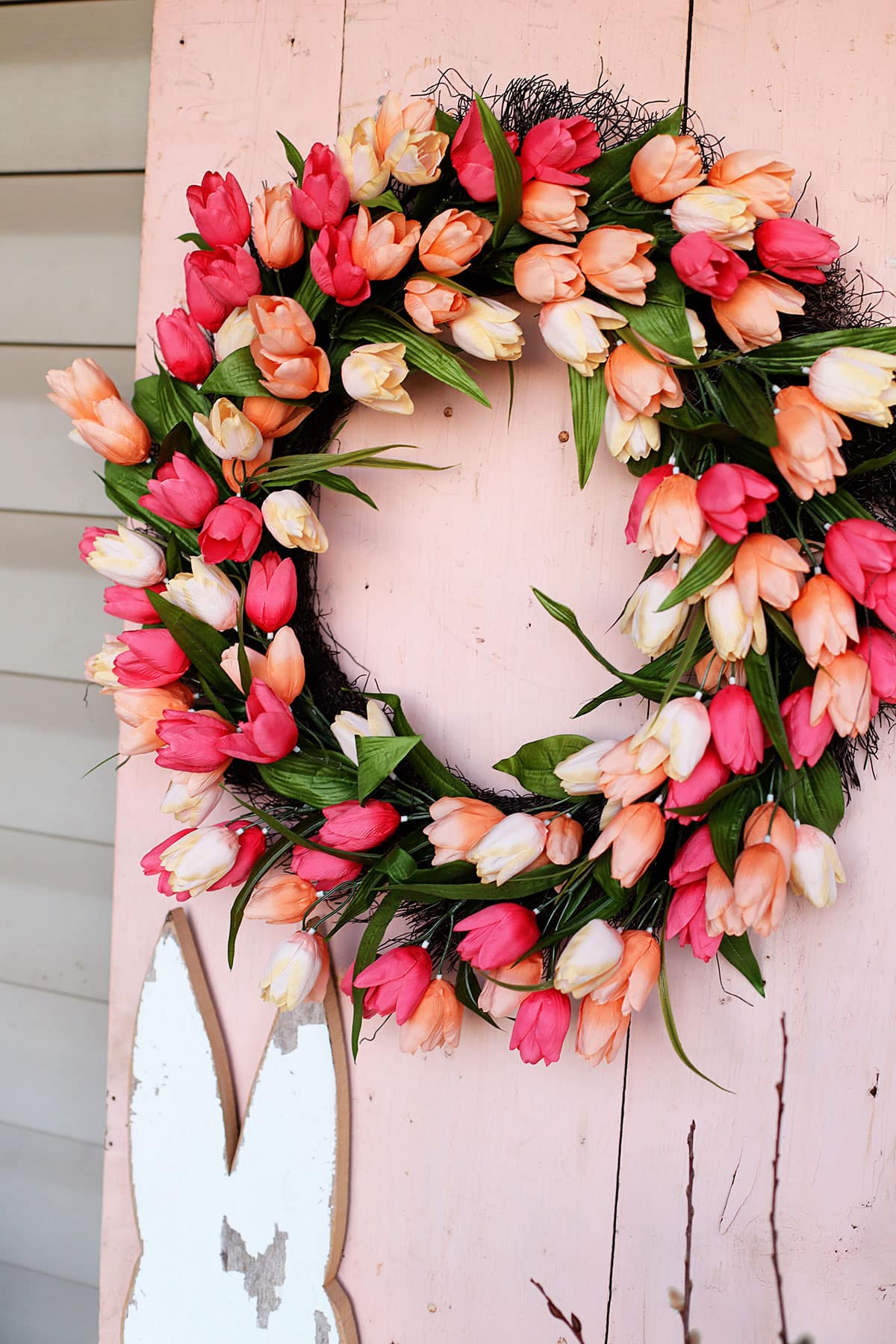 Bright colorful spring wreath on a pink door.