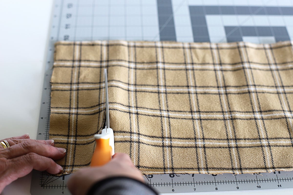 Cutting brown flannel fabric for a rag wreath.