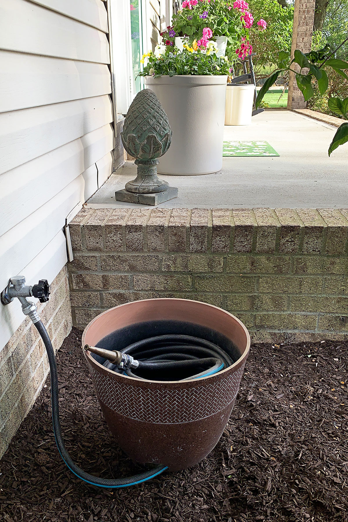 DIY garden hose pot made from a flower container.
