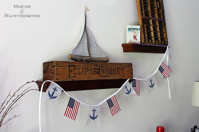 A super easy DIY patriotic banner tutorial. Anchors, flags and sailboats combine for a nautical Fourth Of July home decor style or any patriotic holiday.