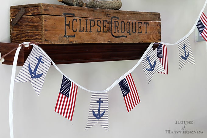 A super easy DIY patriotic banner tutorial. Anchors, flags and sailboats combine for a nautical Fourth Of July home decor style or any patriotic holiday.