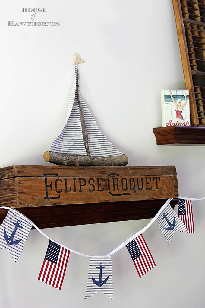 A super easy DIY patriotic banner tutorial. Anchors, flags and sailboats combine for a nautical Fourth Of July home decor style or any patriotic holiday.