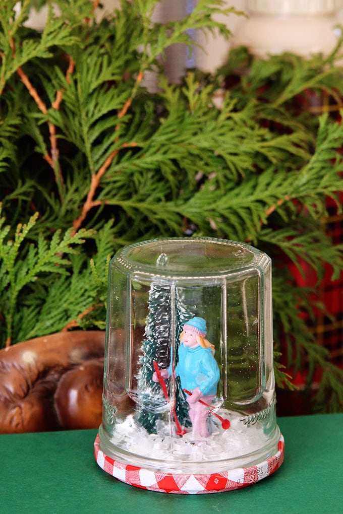 Learn how to make a super cute DIY snow globe from a jelly jar. A quick, easy and inexpensive holiday craft project the kids can help with.