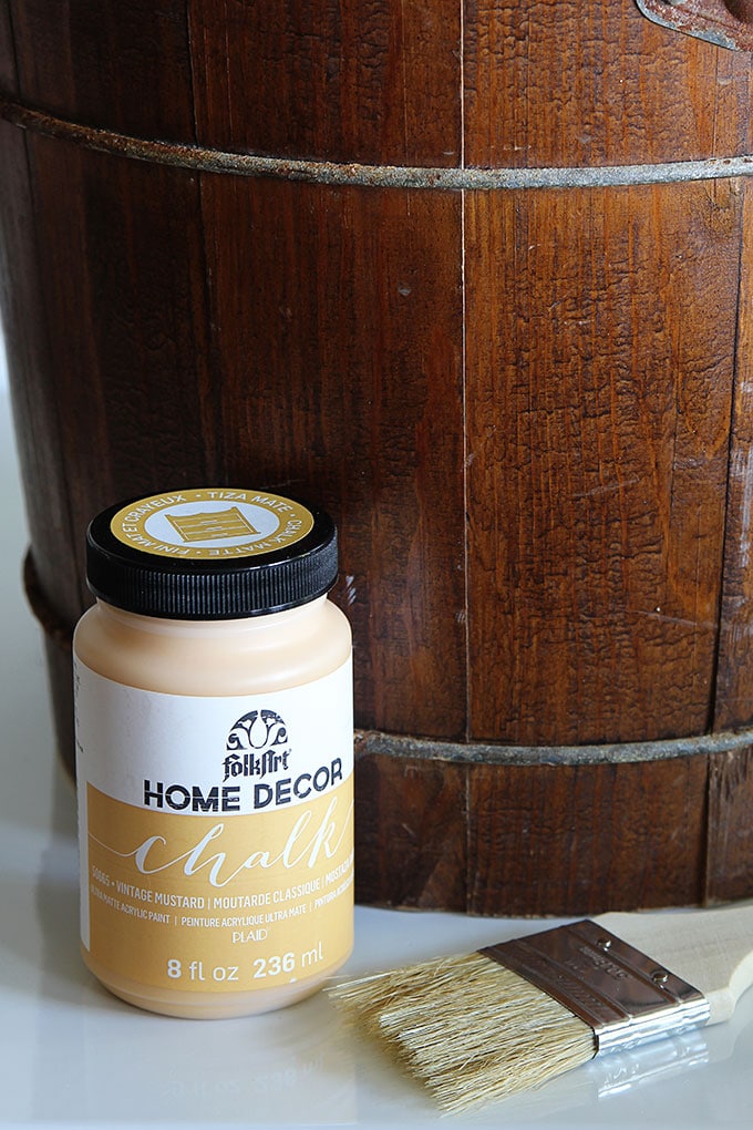 An old yard sale ice cream maker is turned into a rustic wooden planter with the help of chalk paint. A great way to upcycle a common thrift store find!