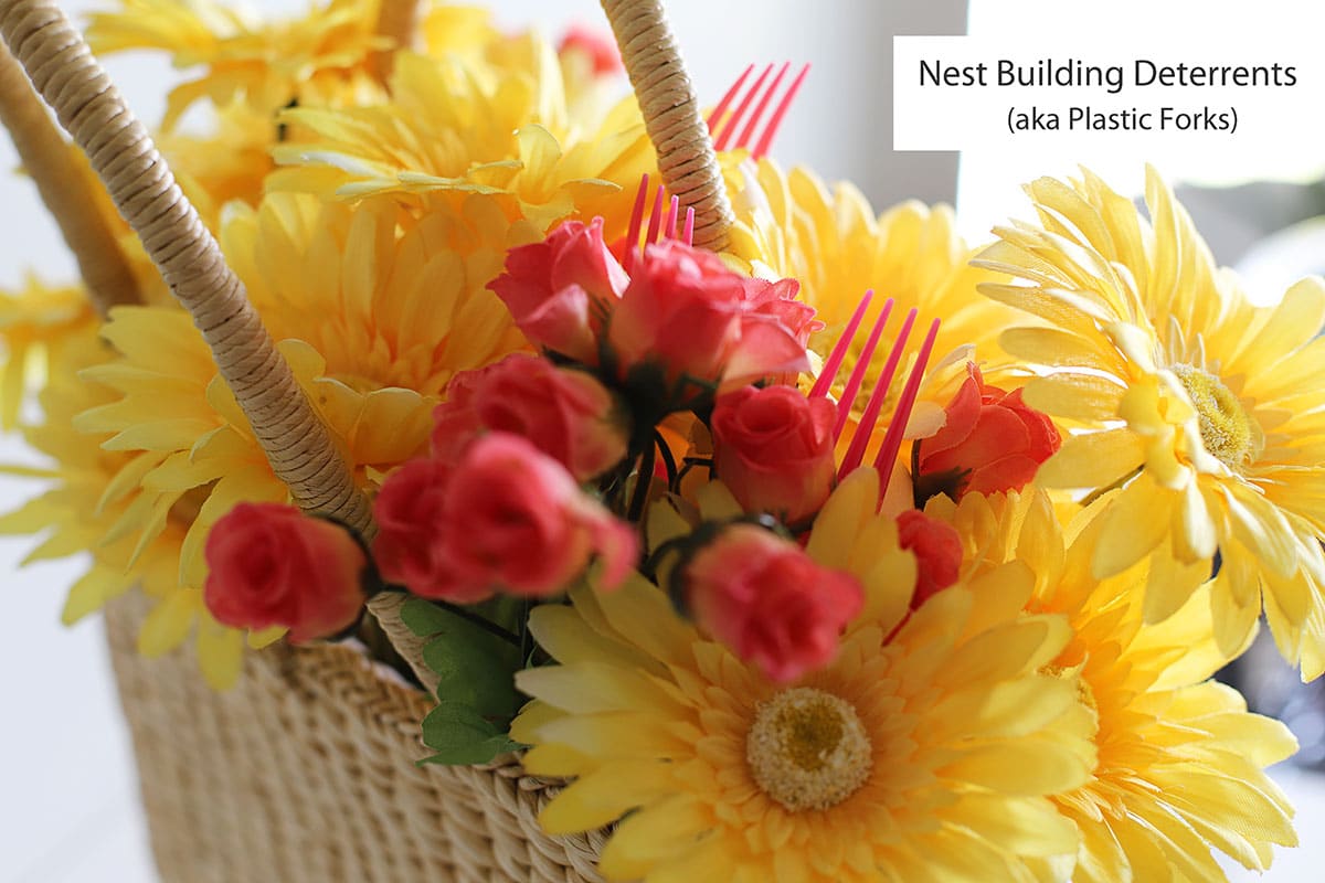 Forks sticking out of the flowers in the purse - helps keep birds from building nests in wreaths.