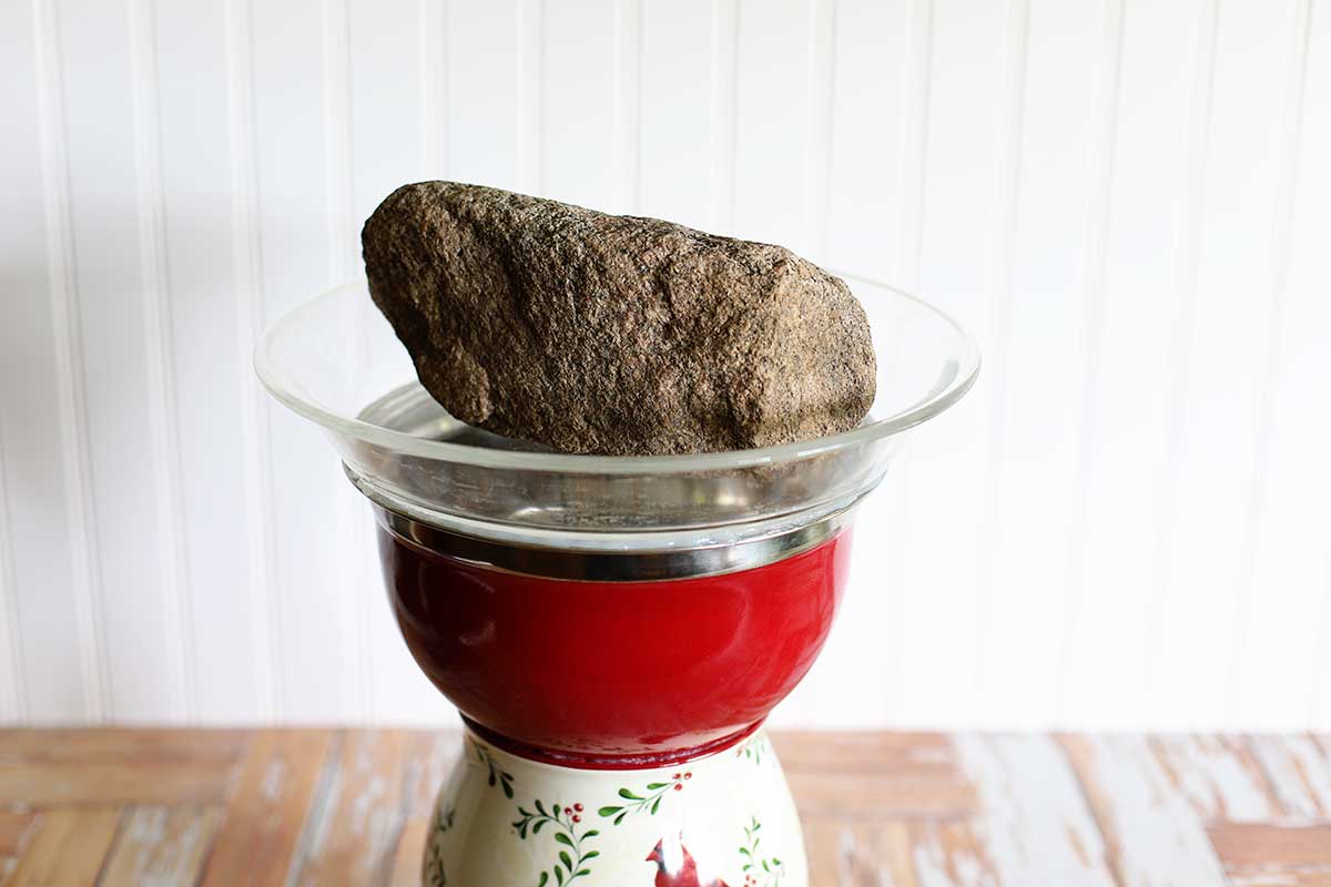 Stone setting on a pie plate - being made into a homemade bird bath.