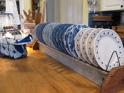 Vintage chicken feeder used as a plate rack.