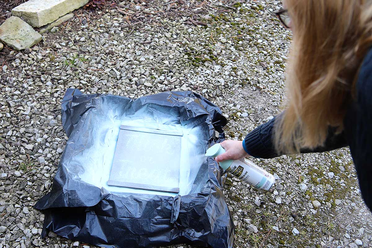 spray painting the tobacco basket outside on the gravel