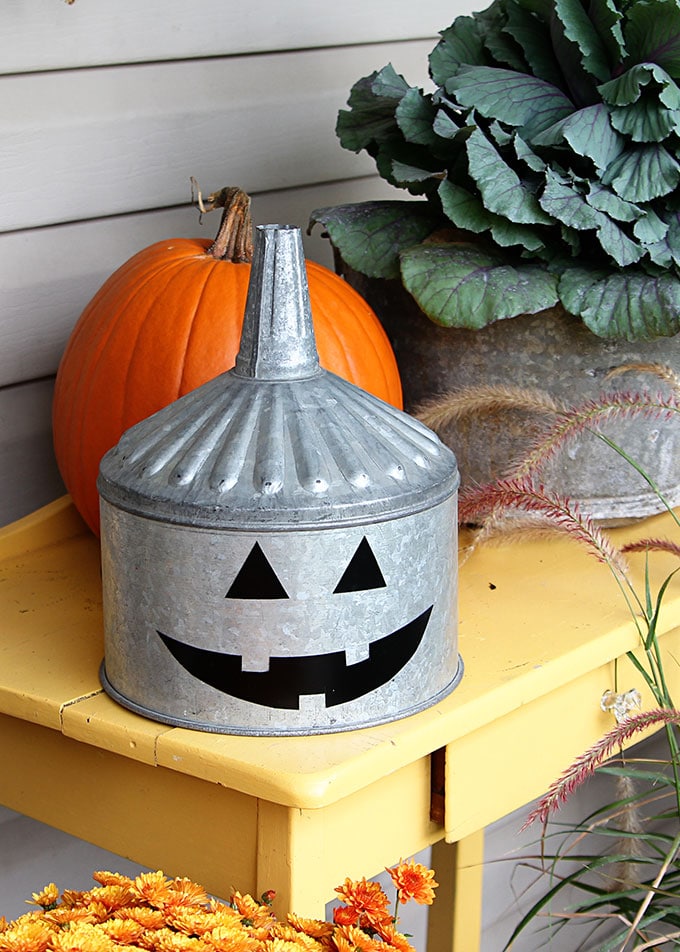 A super cute repurposed Jack-o-Lantern for Halloween made from a galvanized funnel. A quick and easy DIY project for fall!