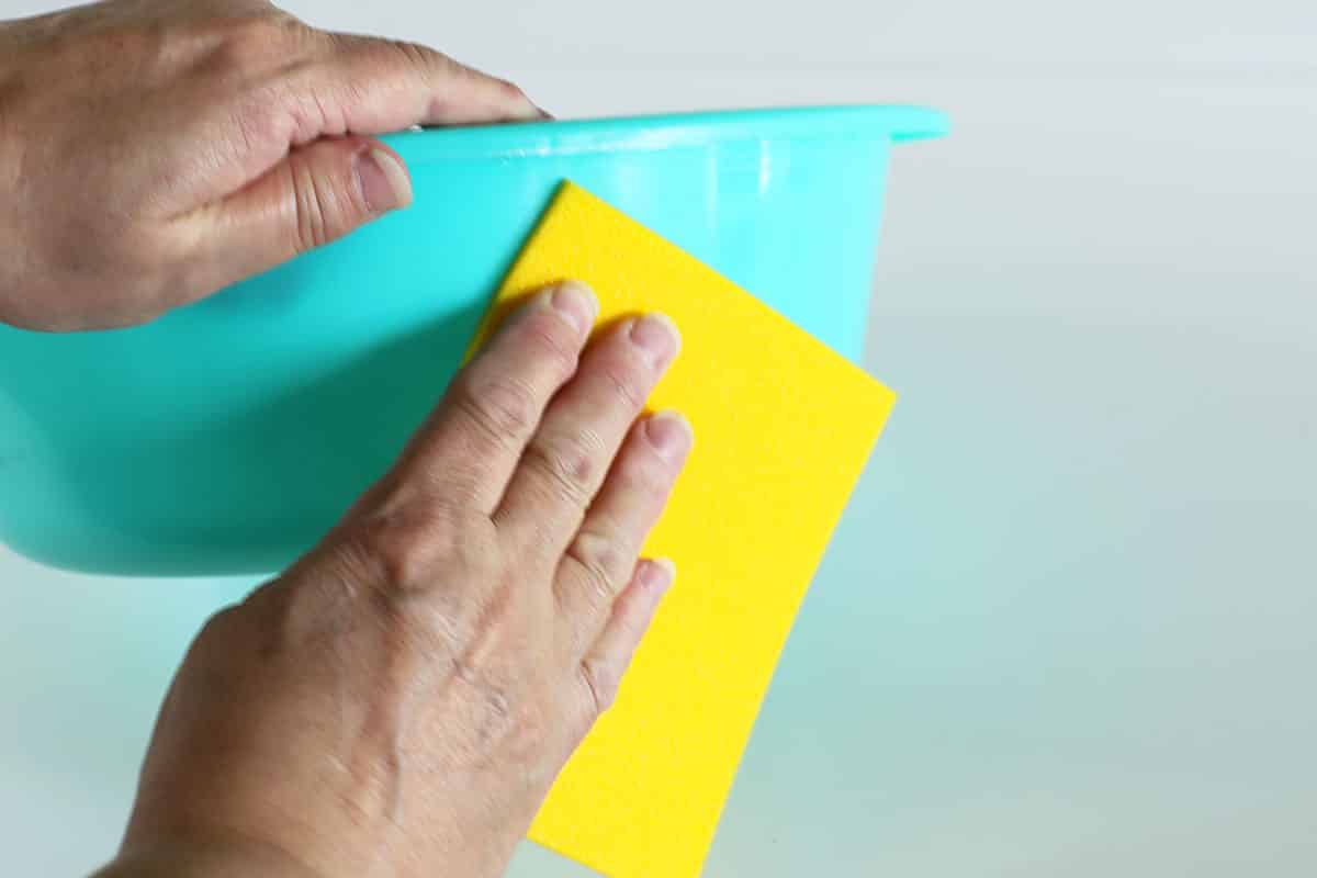 Using a sanding pad to scuff up plastic prior to painting it.