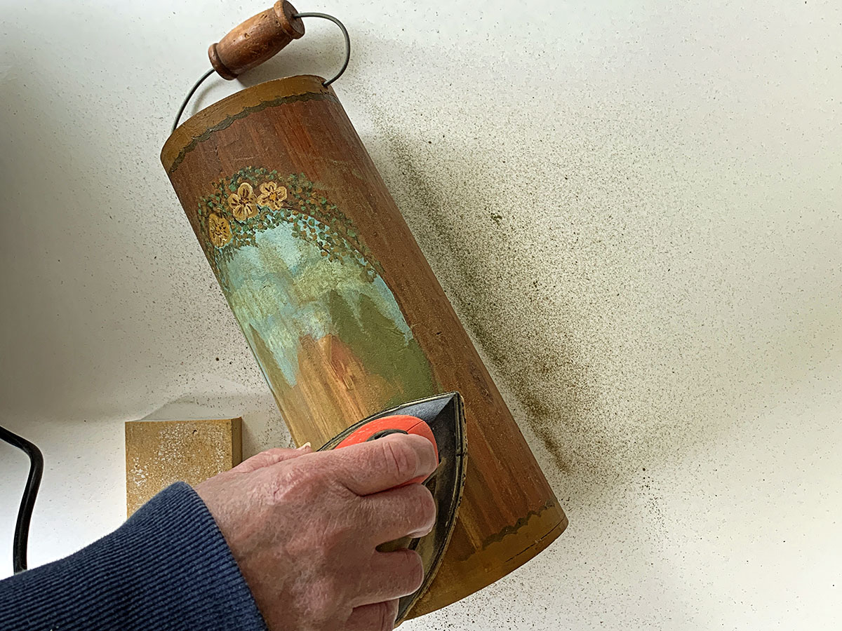 Sanding paint off a wooden bucket.  Using a Black And Decker Mouse Sander.