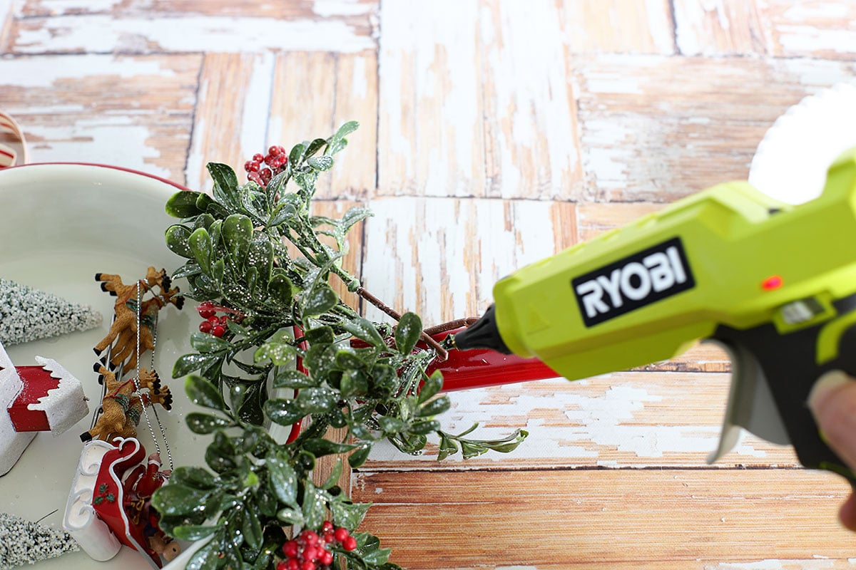 Gluing greenery to the top of the frying pan for decoration.