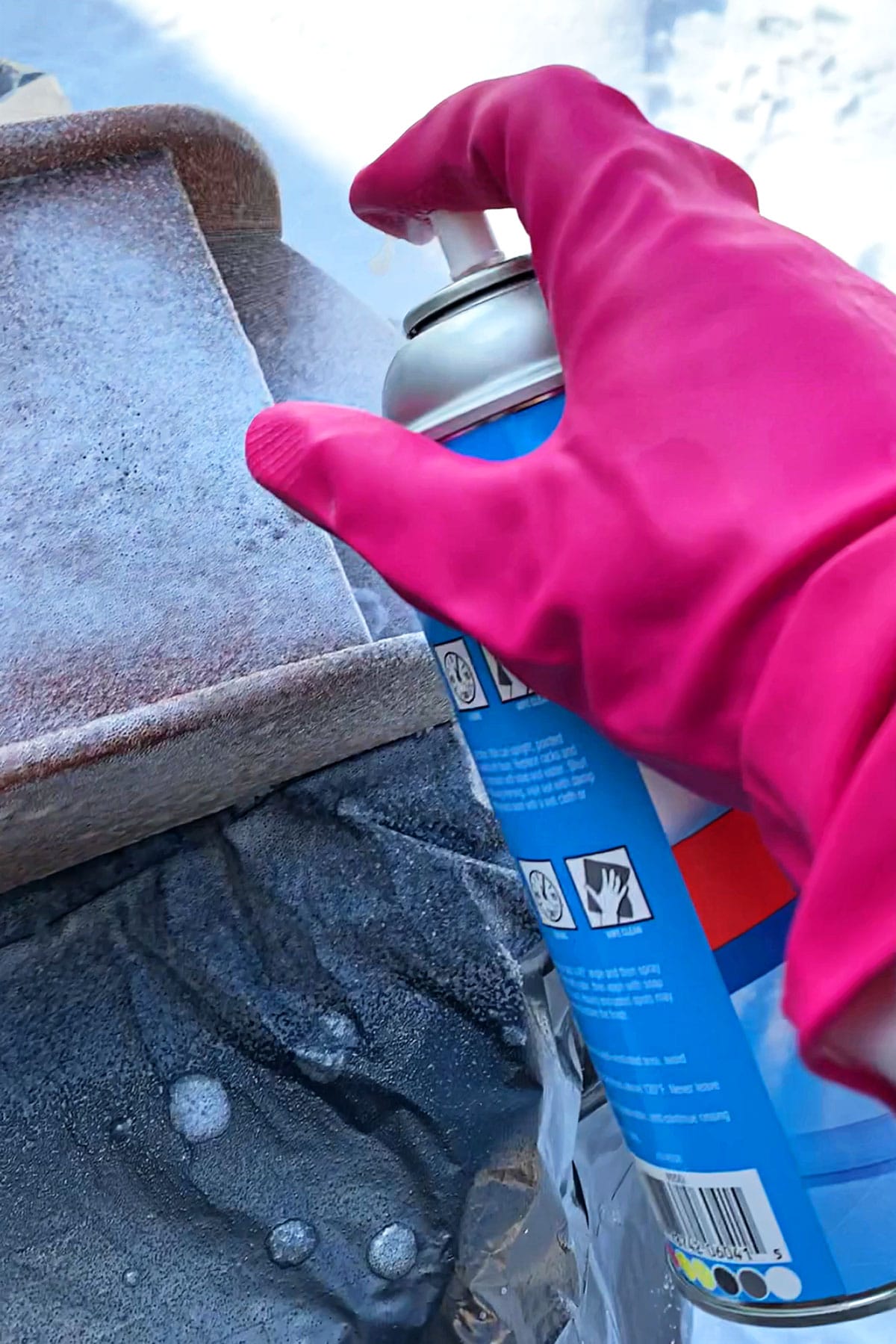 Applying oven cleaner to wood in order to strip the finish off.