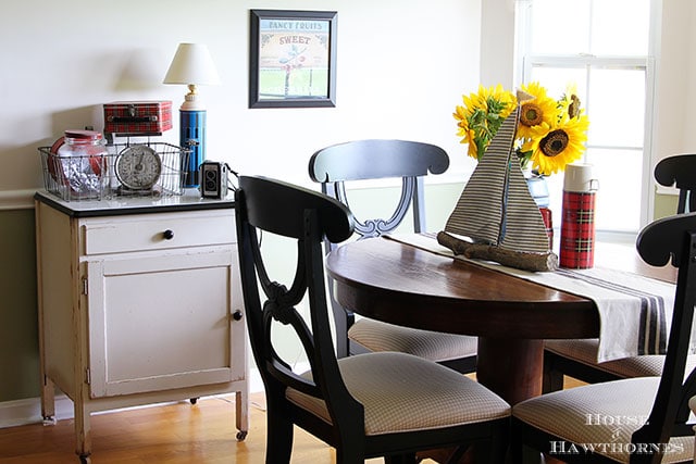 Sunflower vignette using vintage picnic jug, thermoses and twig sailboat