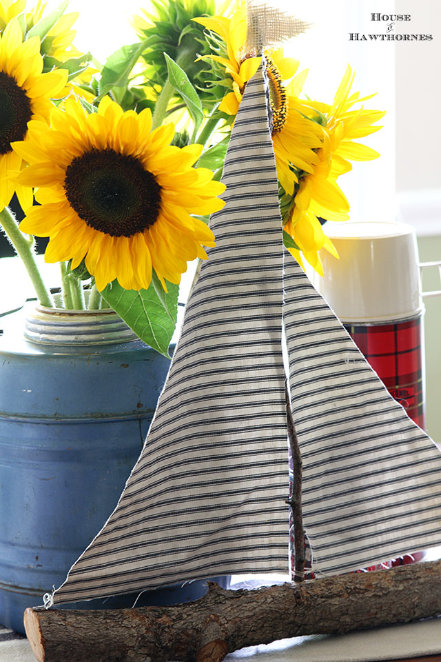 Sunflower vignette using vintage picnic jug, thermoses and twig sailboat