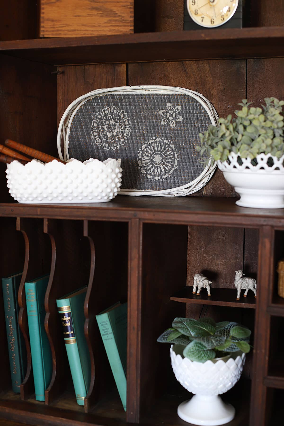 Upcycled boho bamboo tray turned into a fun piece of home decor. Shown as part of the decor pieces on a bookshelf.