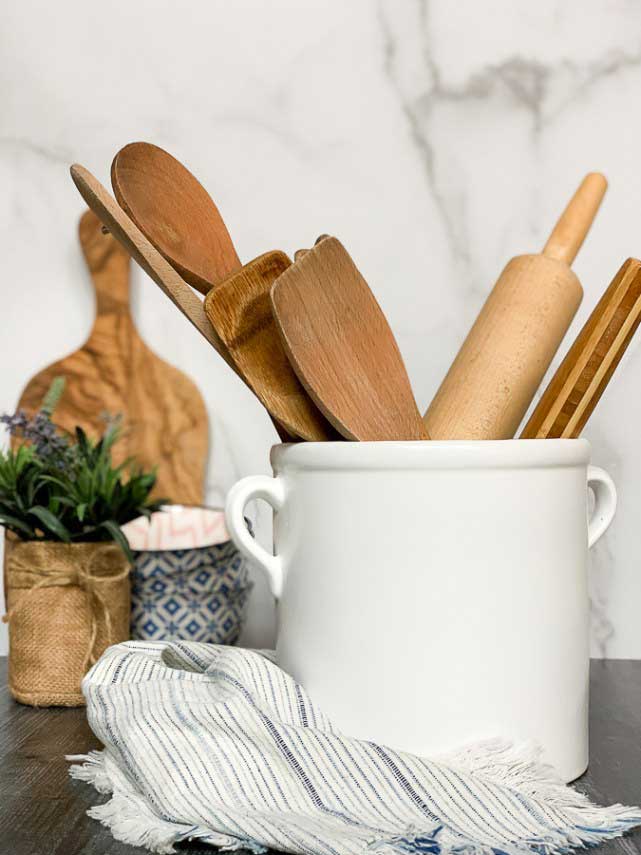 Farmhouse stoneware crock holding rolling pin and wooden kitchen utensils