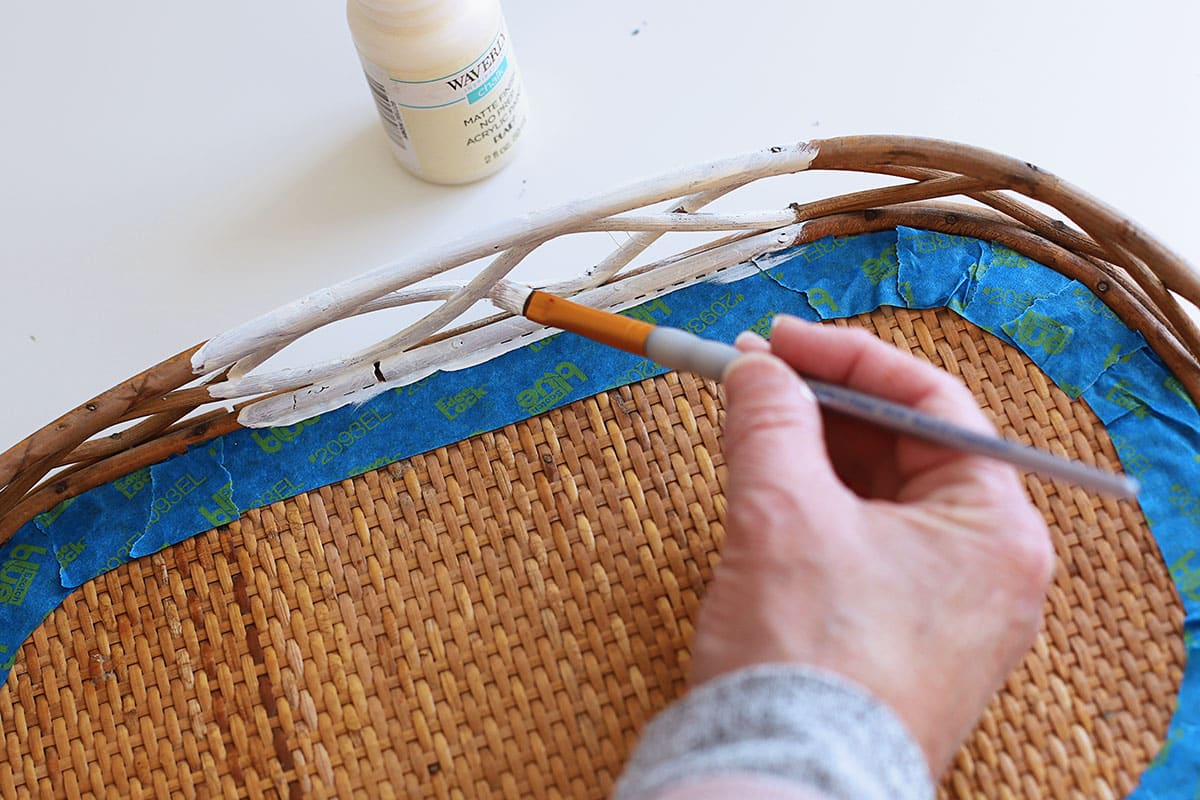 Painting the sides of the tray with white paint.