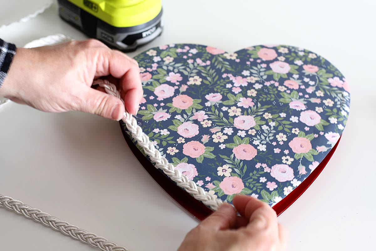 Adding braided trim to an upcycled candy box for Valentine's Day.