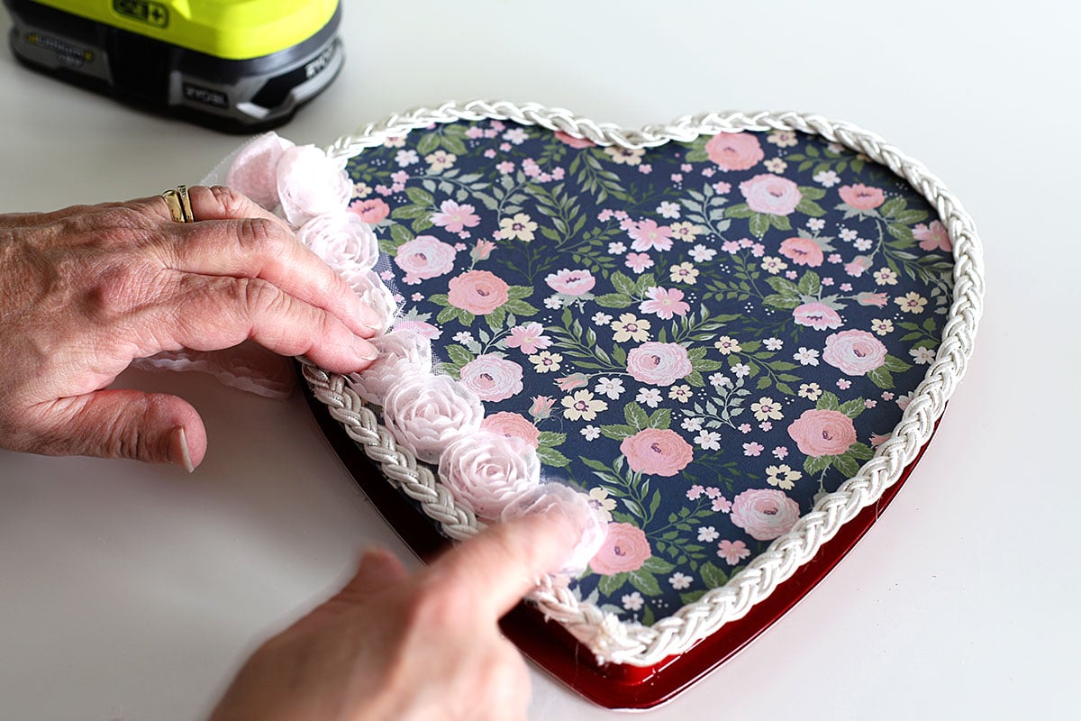 Gluing rose ribbon onto candy box.