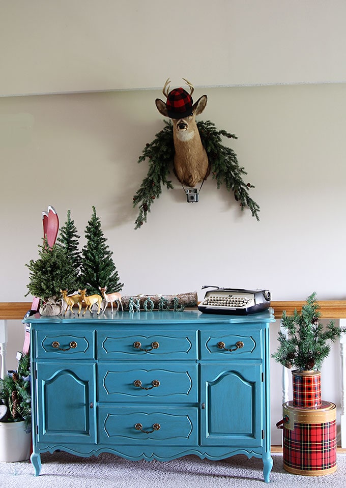 A fun and sassy vintage eclectic holiday home complete with a few kitschy blow molds, a small herd of plastic deer and plaid thermoses galore.