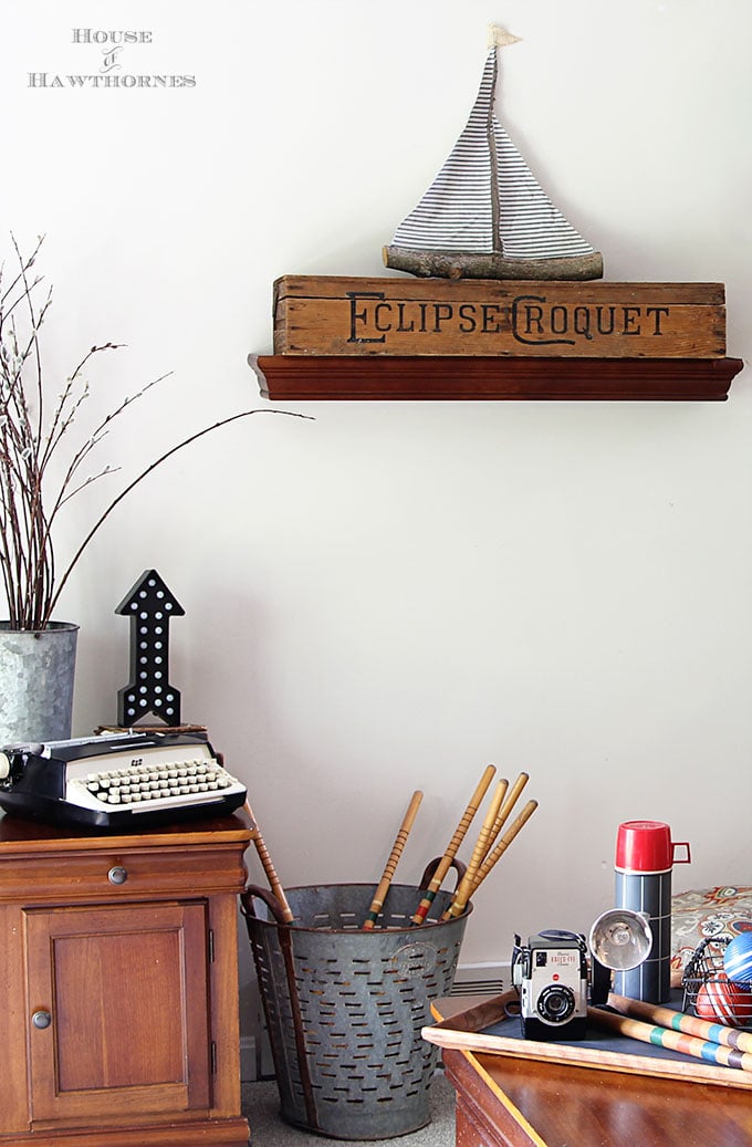 A rustic vintage eclectic style summer home decor tour including vintage thermoses, cameras, typewriter and vintage croquet and badminton equipment.