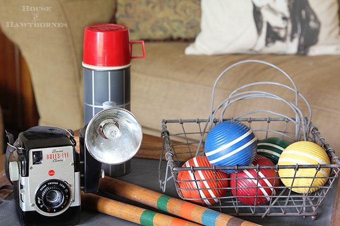 A rustic vintage eclectic style summer home decor tour including vintage thermoses, cameras, typewriter and vintage croquet and badminton equipment.