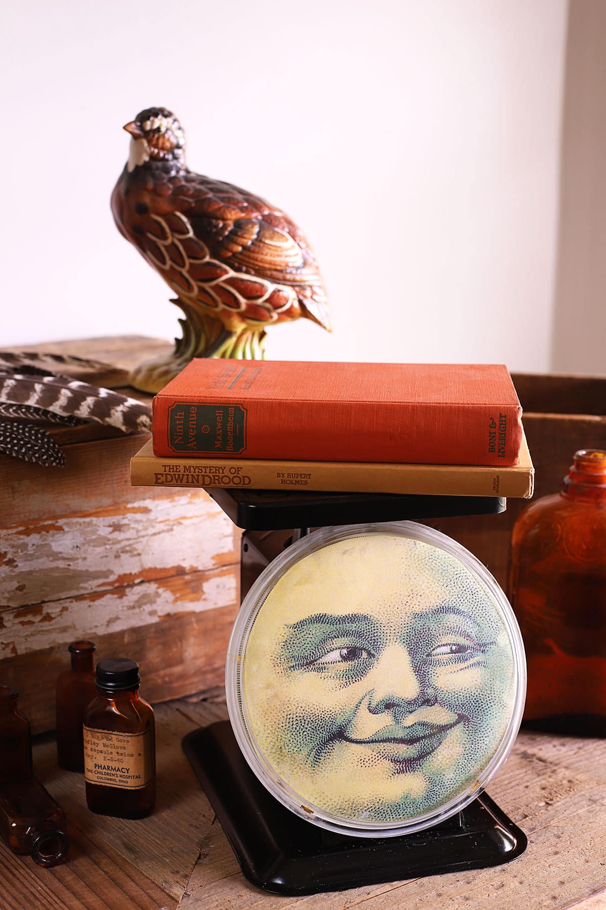 Vintage metal kitchen sdcale repurposed with a man in the moon face on the scale plate. 