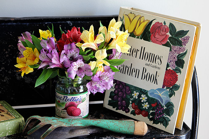 Vintage style garden decorating in the entryway, including vintage garden planters, gardening tools and colorful retro Better Homes and Gardens Garden Book.