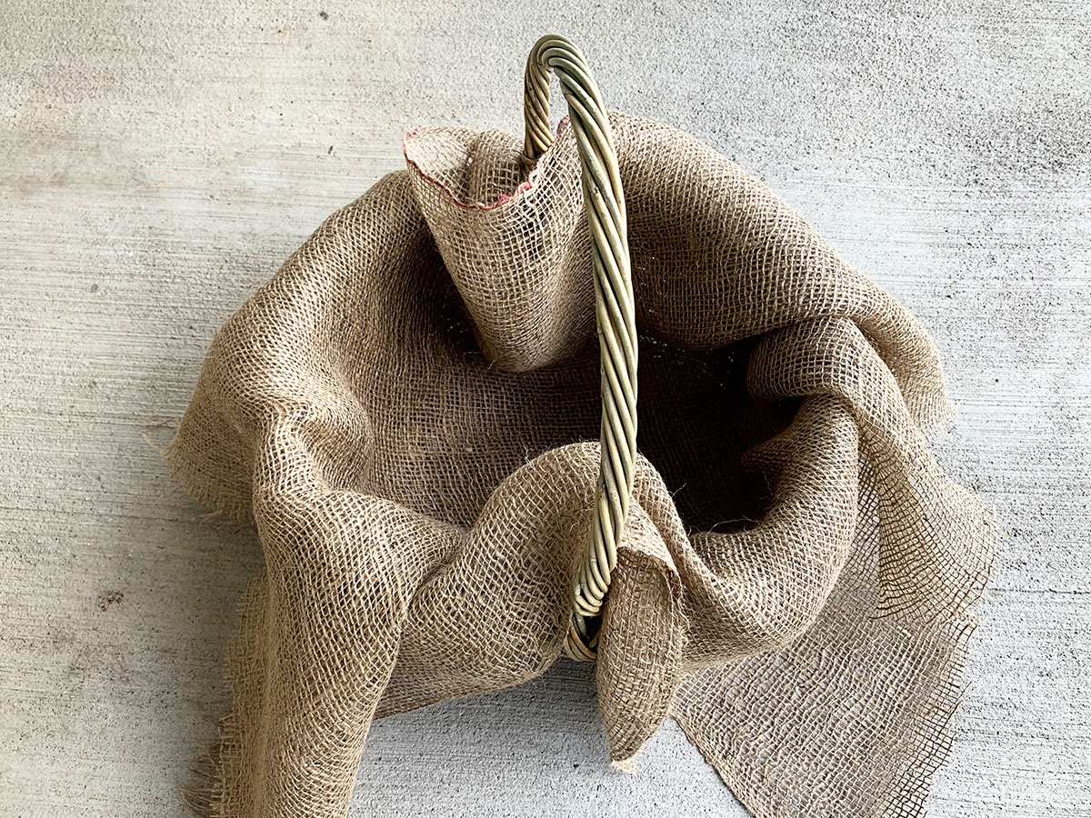 Using a wicker basket lined with burlap as a container garden for the porch.