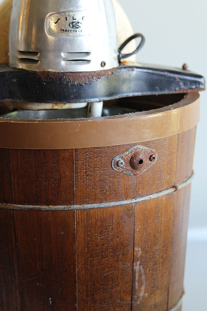 An old yard sale ice cream maker is turned into a rustic wooden planter with the help of chalk paint. A great way to upcycle a common thrift store find!